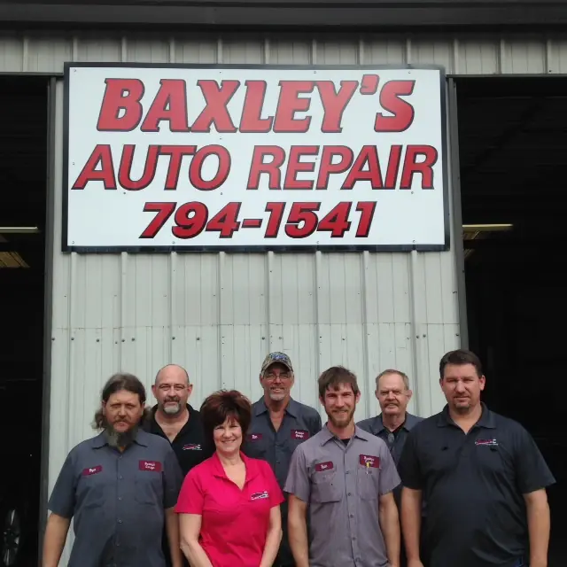 The Baxley's Auto Repair team outside the shop under the sign